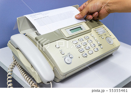 hand man are using a fax machine in the office 55355461