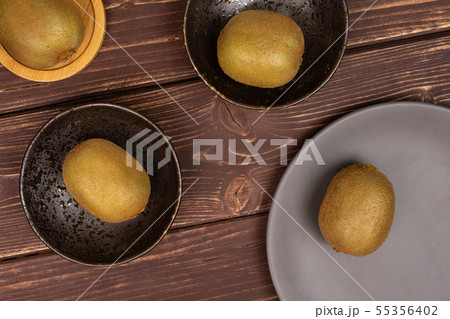 Fresh green kiwi on brown wood Fresh green kiwi on brown wood 55356402