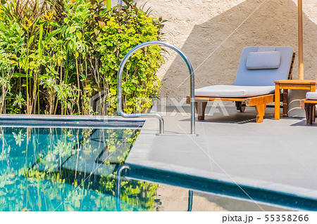 Umbrella and chair around swimming pool neary sea ocean beach with blue sky and white cloud 55358266