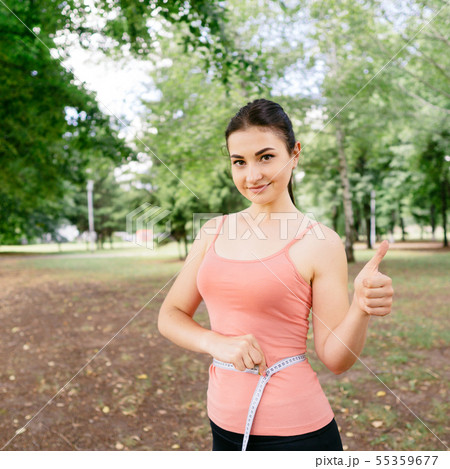 Woman with slim body measuring her waistline 55359677