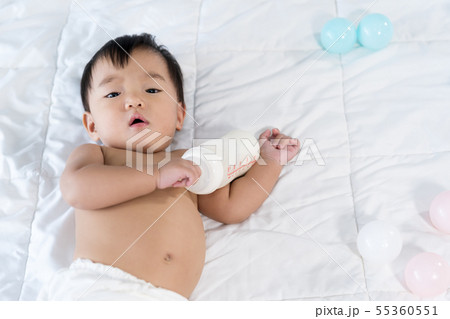 cheerful baby lying on bed 55360551