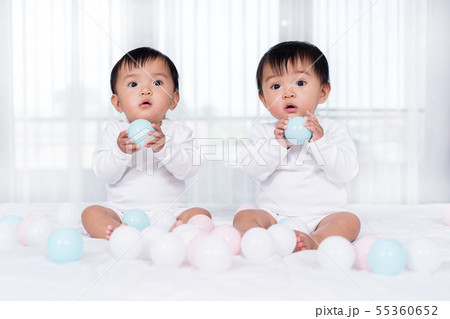 cheerful twin babies playing color ball on  bed 55360652
