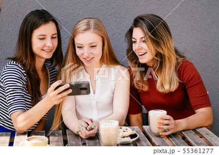 Three friends shopping online sitting at cafe 55361277