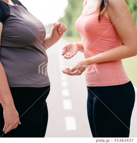Overweight woman take slimming pills from friend Overweight woman take slimming pills from friend 55363437