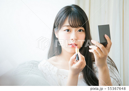 口紅を塗る若い女の子の写真素材