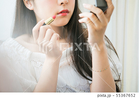 口紅を塗る若い女の子の写真素材