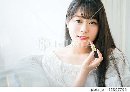 口紅を持つ若い女の子の写真素材