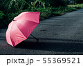 Pink umbrella on concrete floor and green grass fi 55369521