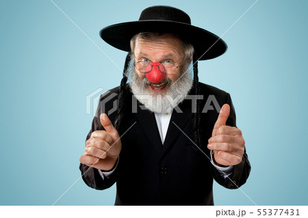 Portrait of an senior jewish man celebrating red nose day Portrait of an senior jewish man celebrating red nose day 55377431