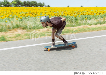 Skateboarder doing a trick at the city's street in sunny day Skateboarder doing a trick at the city's street in sunny day 55377592