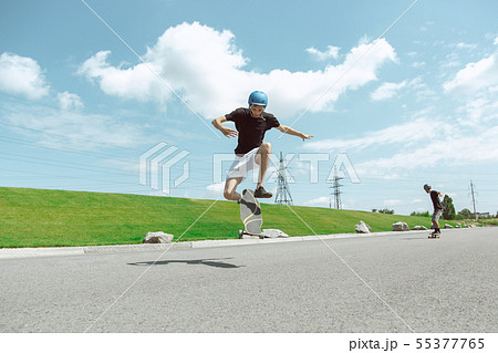 Skateboarders doing a trick at the city's street in sunny day 55377765