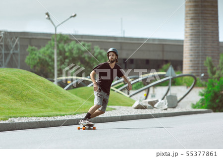 Skateboarder doing a trick at the city's street in sunny day 55377861