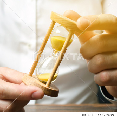 Businessman holds clock in hands. 55379699