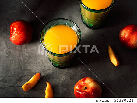 Still life of fresh nectarines with droplets of water and juice in turquoise vintage glasses on dark Still life of fresh nectarines with droplets of water and juice in turquoise vintage glasses on dark 55380921