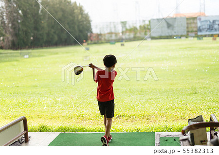 Young asian boy is practicing his golf swing at the golf driving range. 55382313