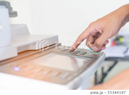 a man is pressing the botton of printer 55384197