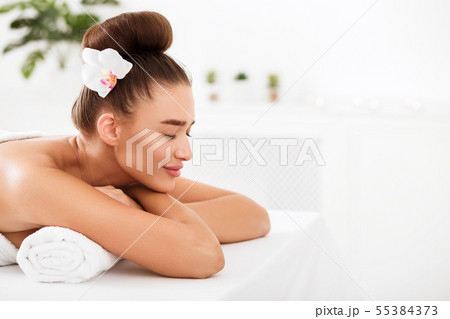 Beautiful woman relaxing at spa salon, copy space 55384373
