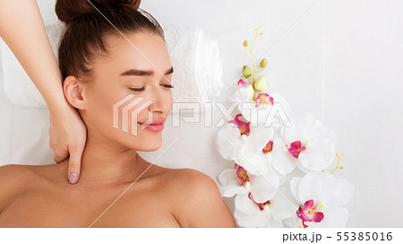 Relaxed woman receiving neck massage in beauty parlor 55385016