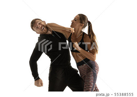 Man and woman fighting in studio, women's self-defense concept Man and woman fighting in studio, women's self-defense concept 55388555