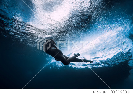 Woman dive underwater with ocean wave. Woman dive underwater with ocean wave. 55410159