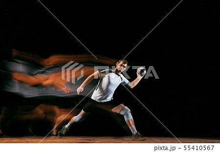 Young handball player against dark studio background in mixed light Young handball player against dark studio background in mixed light 55410567