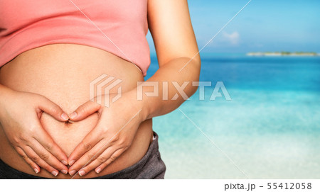 Pregnant woman feeling happy at the beach. 55412058