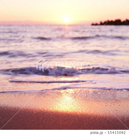 砂浜に沈む夕日の写真素材