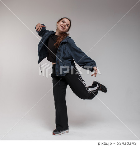 Cheerful young woman dancer with brown long hair 55420245