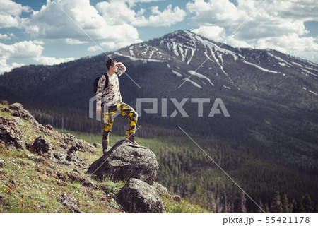 Excited man hiking on a mountain top with backpack Excited man hiking on a mountain top with backpack 55421178