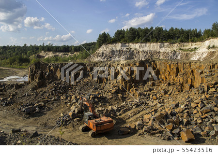 Excavator and basalt columns rocks. Heavy industry 55423516
