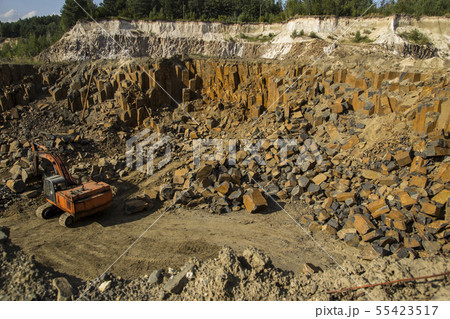 Excavator and basalt columns rocks. Heavy industry 55423517