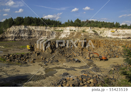 Excavator and basalt columns rocks. Heavy industry 55423519