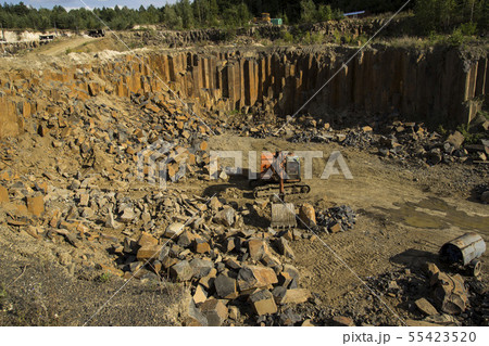 Excavator and basalt columns rocks. Heavy industry 55423520