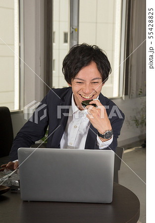 パソコン画面を見ながら、おにぎりを食べながら仕事 55428825