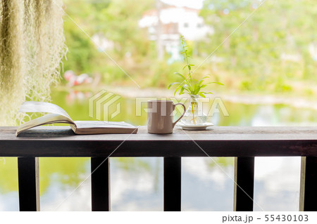 Cup of coffee with open book on wooden top in the morning. 55430103