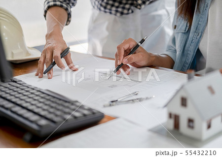 Engineers discuss a blueprint while checking 55432210