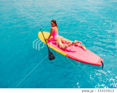 Woman relax on stand up paddle board on blue ocean Woman relax on stand up paddle board on blue ocean 55433913