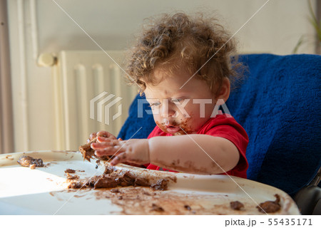 baby is eating a chocolate cake baby is eating a chocolate cake 55435171