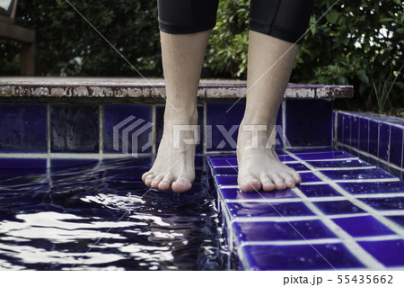 Dipping toe in swimming pool Dipping toe in swimming pool 55435662