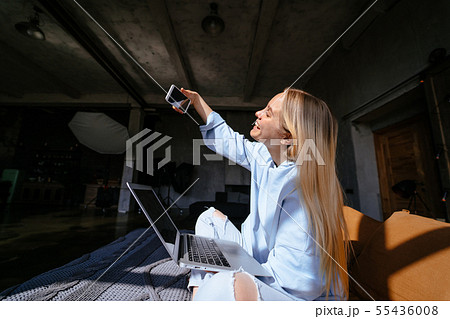 Smiling attractive woman lying on bed talking by smartphone Smiling attractive woman lying on bed talking by smartphone 55436008