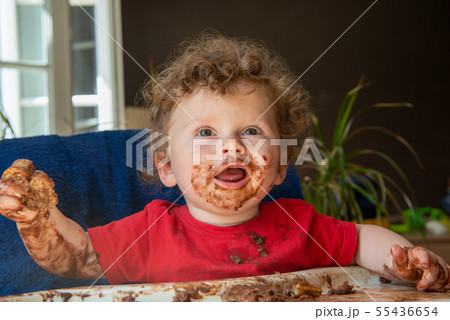 baby is eating a chocolate cake 55436654