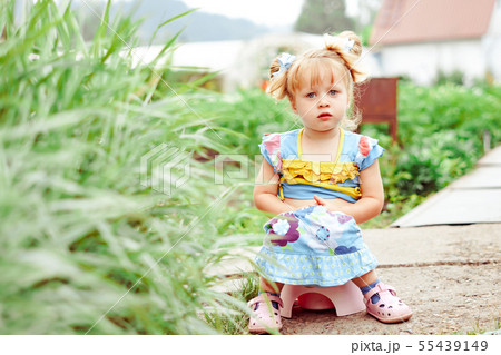 child sitting on a pot in nature child sitting on a pot in nature 55439149