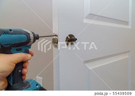 Hands repairing a door lock with a screwdriver Hands repairing a door lock with a screwdriver 55439509