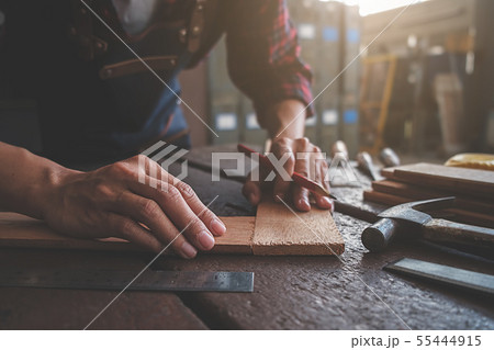 Carpenter working with equipment on wooden table 55444915