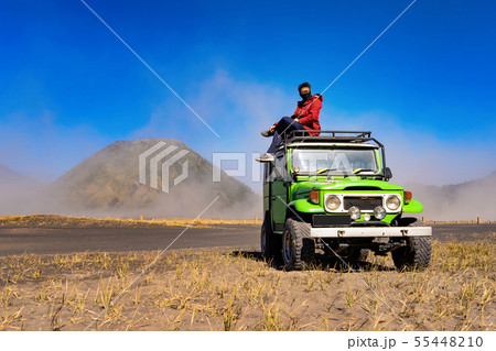 An Asian man wearing mask and sitting on jeep car An Asian man wearing mask and sitting on jeep car 55448210