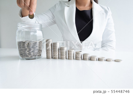 woman hand putting coin into glass bottle bank woman hand putting coin into glass bottle bank 55448746