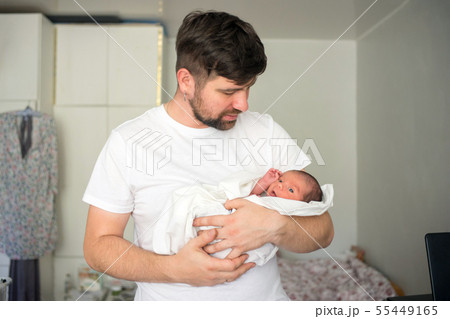 Father holds naked newborn son in his hands in a white diaper 55449165