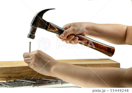 Lady Hand hoiding hammer hitting a nail on wooded  55449248