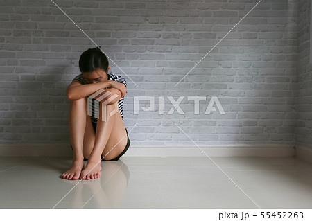 Woman sad depressed sitting on a sofa in the Woman sad depressed sitting on a sofa in the 55452263