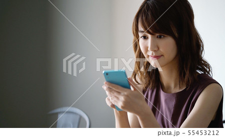 カフェでスマホを見る女性 55453212